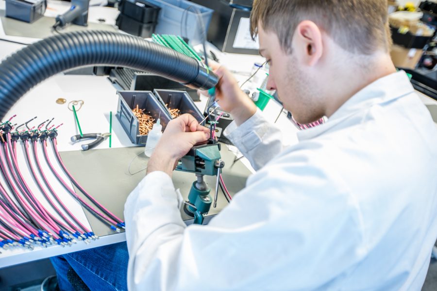 Operator assembling a wire harness at a workbench