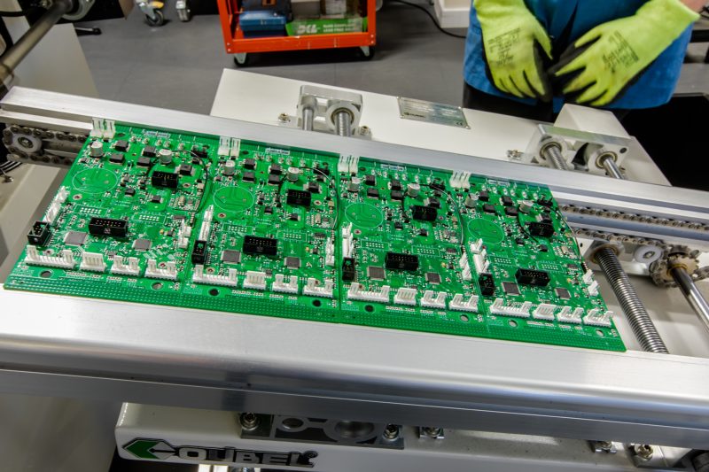 Assembled PCB panels on a conveyor